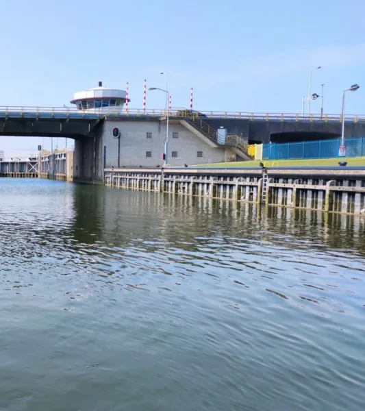 Baggeren van slib op betonvloer bij de Algerasluis Hollandse IJssel